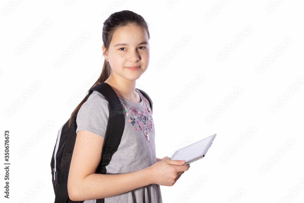 schoolgirl holds a tablet in her hands and looks away schoolgirl holds a tablet in her hands and looks away