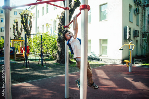 Wallpaper Mural little cute blond boy hanging on playground outside, alone training with fun, lifestyle children concept Torontodigital.ca