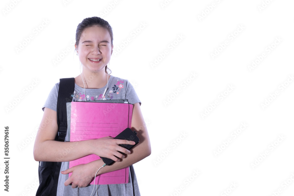 schoolgirl laughs, holds notebooks and a smartphone in her hands schoolgirl laughs, holds notebooks and a smartphone in her hands