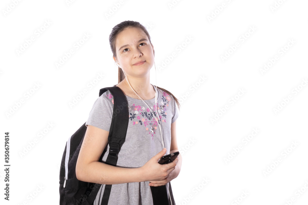 young schoolgirl with a backpack holds a smartphone in her hands young schoolgirl with a backpack holds a smartphone in her hands