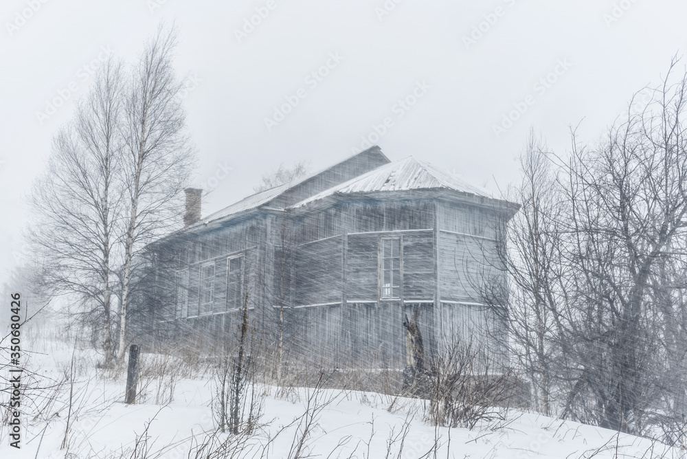 Old house in the village of Karelian Maselga during a snowstorm. Republic of Karelia. March 2020 Old house in the village of Karelian Maselga during a snowstorm. Republic of Karelia. March 2020
