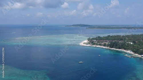 drone flying along gili air island against the backdrop of gili meno trawangan islands in sunny weather