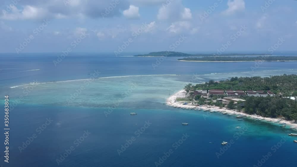 drone flying along gili air island in sunny weather a large hotel and a coral reef are visible drone flying along gili air island in sunny weather a large hotel and a coral reef are visible