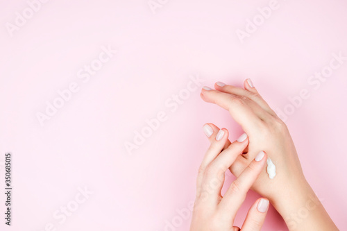 Gentle well-groomed female hands with Nude manicure.