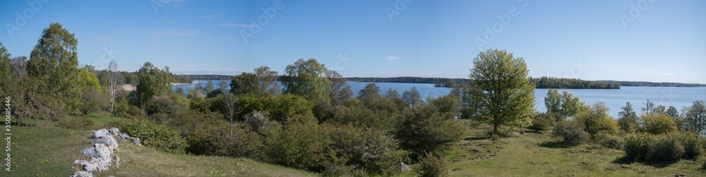 Spring landscape at a old viking tumulus on the island Adelsö and the church Adelsö kyrka close to Stockholm Spring landscape at a old viking tumulus on the island Adelsö and the church Adelsö kyrka close to Stockholm