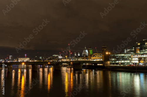 Night photo of London with illuminated Thames and building with many lights
