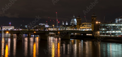 Night photo of London with illuminated Thames and building with many lights
