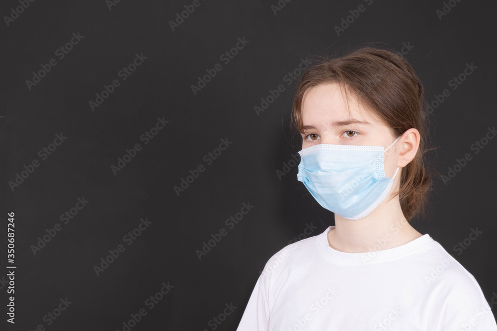young girl with a mask on her face looks forward