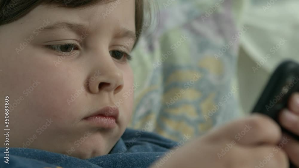 boy with lack of attention from parents all day watch cartoon on the phone while parents working boy with lack of attention from parents all day watch cartoon on the phone while parents working