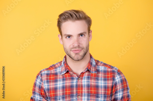 man in casual checkered shirt. handsome guy with bristle on face. male beauty standard. fashion model on yellow background. sexy unshaven man. denim clothing trend. barbershop salon