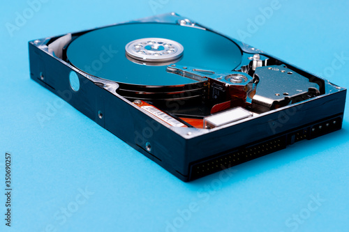 Close up of the inside of a Hard Drive on blue background. data storage concept. Topical data storage unit repairs. information backup and security concept. file recovery services.