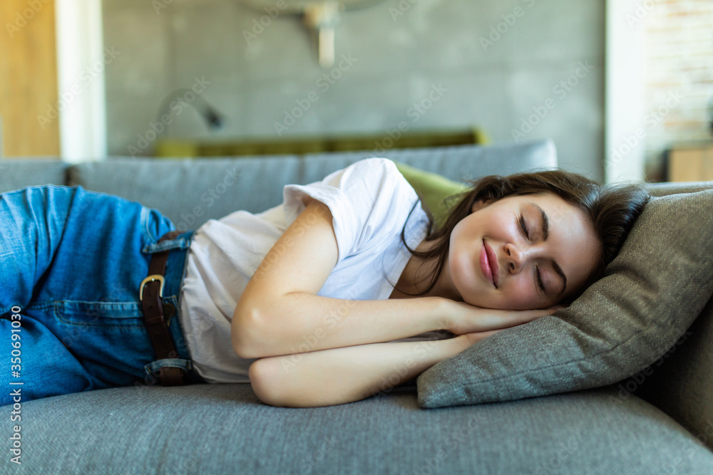 Young sleeping woman is lying on a pillow on a couch Young sleeping woman is lying on a pillow on a couch