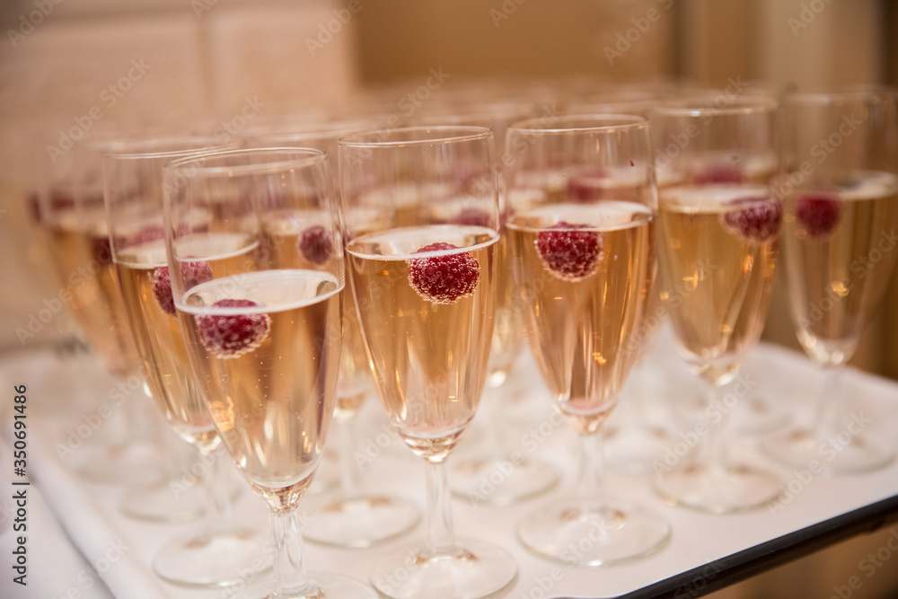 Champagne glasses with raspberries, toast at the wedding