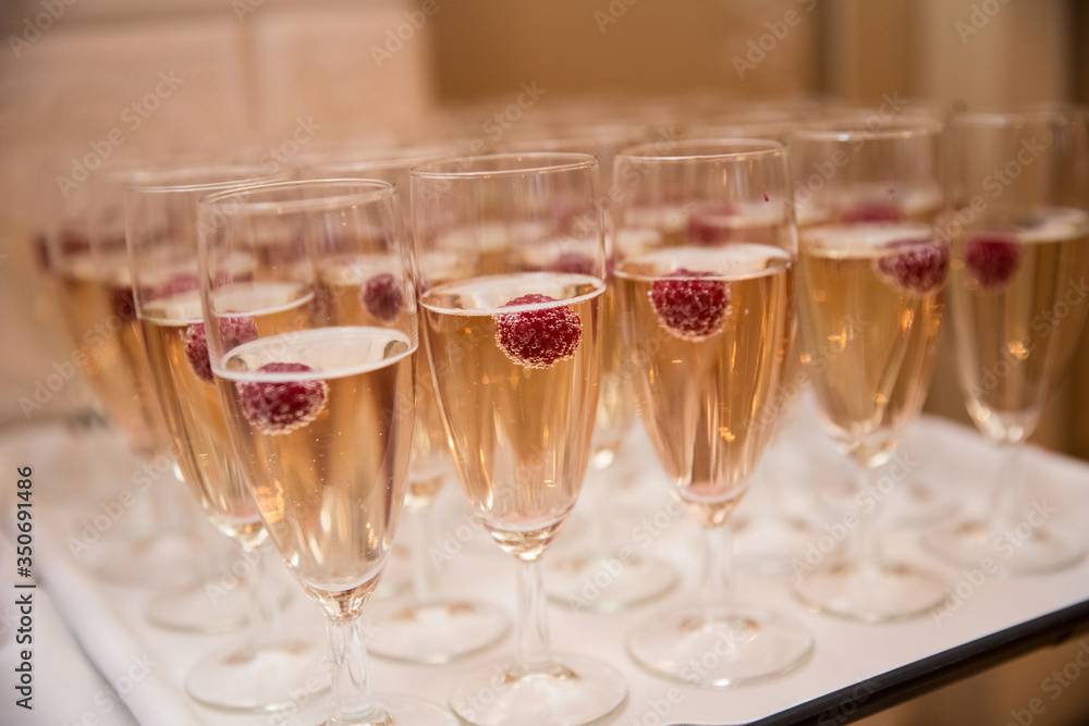 Champagne glasses with raspberries, toast at the wedding Champagne glasses with raspberries, toast at the wedding