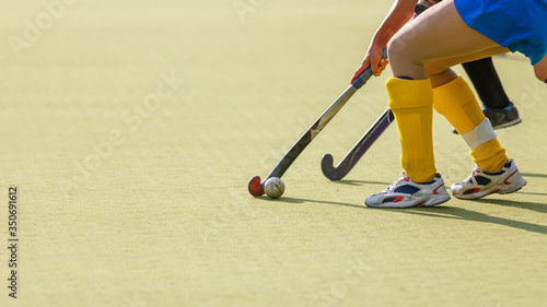 Two field hockey players struggle for the ball