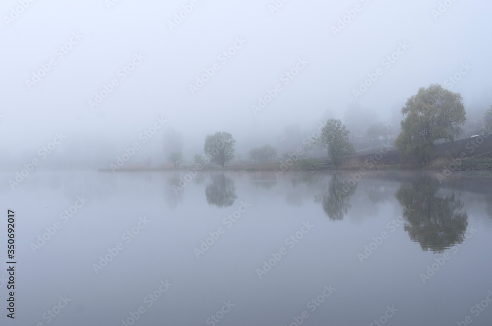 Fototapeta premium Fog on the lake, cloudy morning, poor visibility and high humidity.