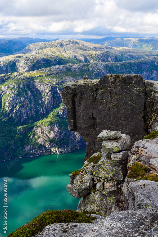 Wonderful mountain landscape of Lysefjorden with clouds reflected in blue water. View from Kjerag plateau, where not far at an altitude of 984 meters stuck between two rocks of Kjeragbolten. Norway. Wonderful mountain landscape of Lysefjorden with clouds reflected in blue water. View from Kjerag plateau, where not far at an altitude of 984 meters stuck between two rocks of Kjeragbolten. Norway.