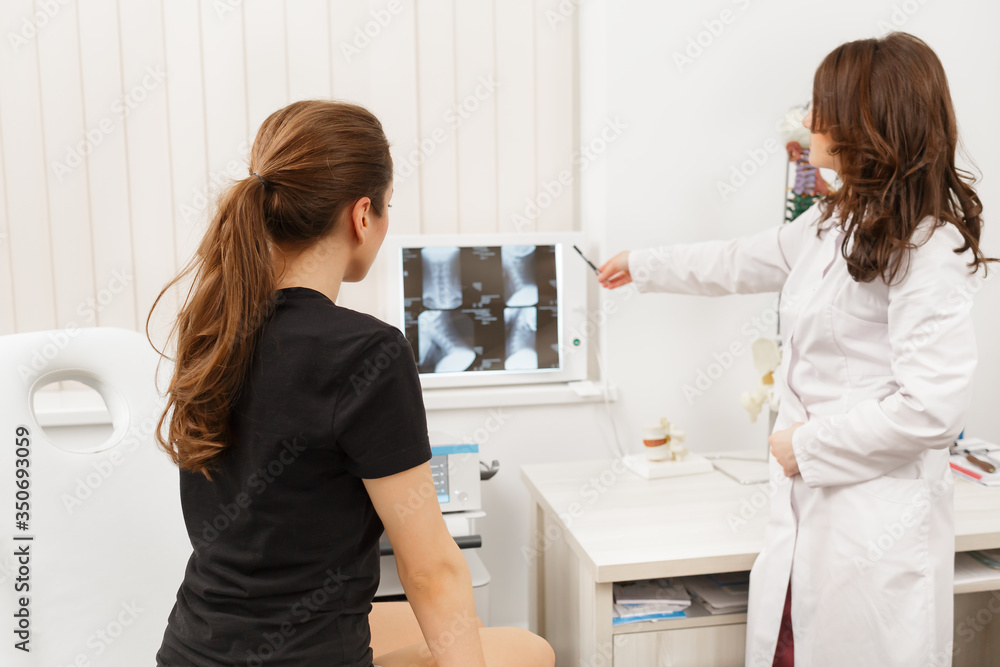 Doctor showing results of X-ray examination to his patient and explains the cause of his pain in medical office. Patient visiting physiotherapist in clinic. Surgery, healthcare and medicine concept. Doctor showing results of X-ray examination to his patient and explains the cause of his pain in medical office. Patient visiting physiotherapist in clinic. Surgery, healthcare and medicine concept.