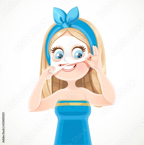 Cute blond girl in a blue bath towel and tied hair removes cosmetic mask from the face isolated on white background