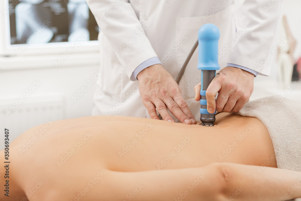 Extracorporeal Shockwave Therapy ESWT.Effective non-surgical  treatment.Physical therapy for lower back with shock waves.Pain relief,  normalization and regeneration,stimulation of healing process. Stock Photo