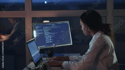 Side view of african american female engineer working on computer in electronics laboratory. Doing Development of Software and Hardware. She wearing a lab coat