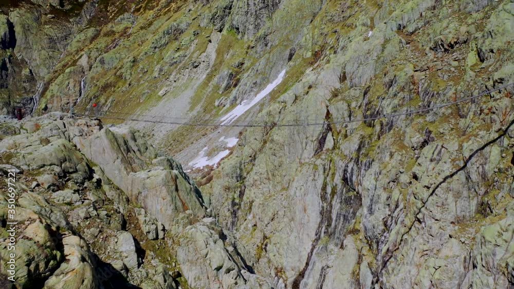 Slow aerial forward shot of bridge connecting mountains in swiss alps Slow aerial forward shot of bridge connecting mountains in swiss alps