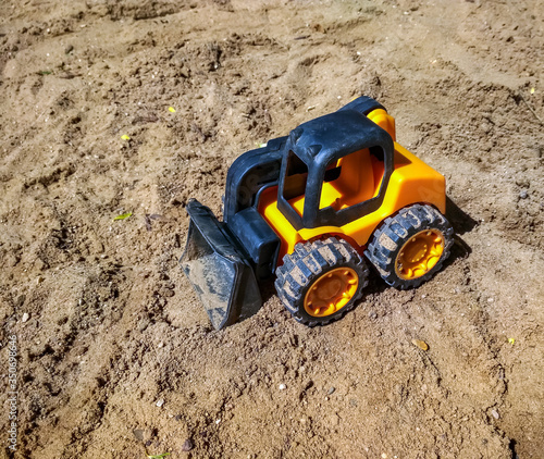 Children's toy tractor in sandbox close up