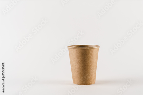 Eco-friendly natural coffee cup with empty space. Disposable ecological utensils on white background. Sustainability of planet. Cardboard glass made of fiber of bamboo and bagasse.