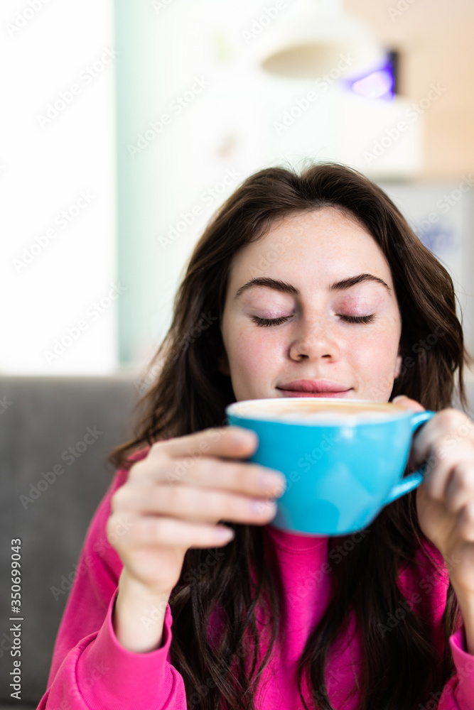 Portrait of beautiful woman drinking a cup of tea in cafeteria. Happy woman in a cafe drinking coffee and looking at camera. Portrait of smiling lady relaxing in a coffee shop. Portrait of beautiful woman drinking a cup of tea in cafeteria. Happy woman in a cafe drinking coffee and looking at camera. Portrait of smiling lady relaxing in a coffee shop.