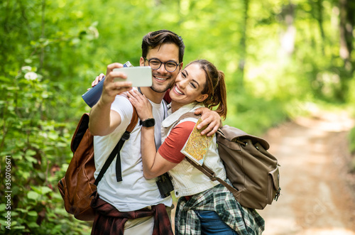 Hiker couple taking a selfie in a forest