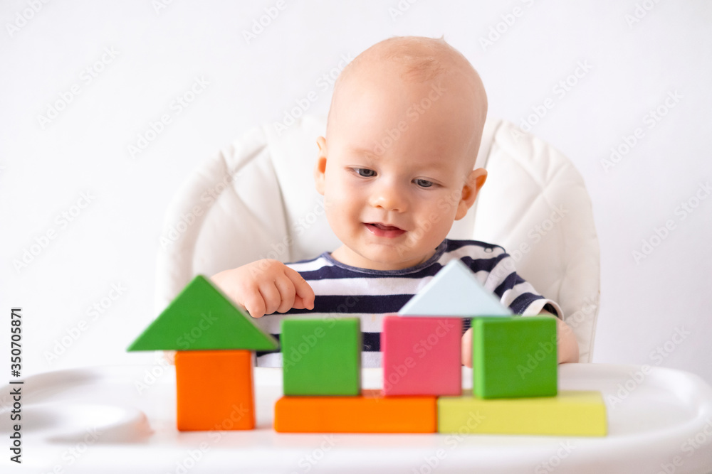 baby game. Little clever caucasian child playing colorful wood toys sitting on highchair. games for early development. New born infant kids leisure. baby game. Little clever caucasian child playing colorful wood toys sitting on highchair. games for early development. New born infant kids leisure.
