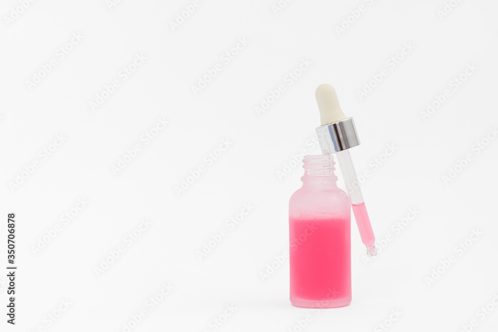 Pipette with collagen moisturizing hyaluron serum with red liquid in a light matt bottle with pipette isolated on grey background. Pipette with collagen moisturizing hyaluron serum with red liquid in a light matt bottle with pipette isolated on grey background.