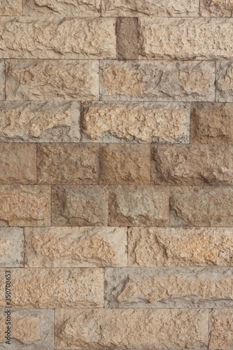 Wall made of yellow natural stone vertical view