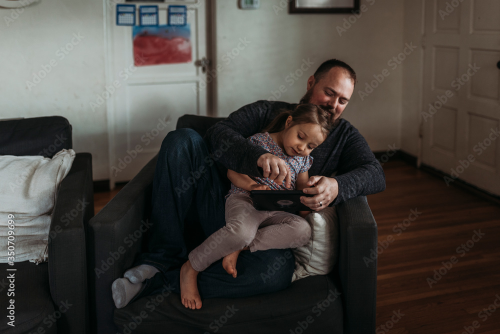 Dad and young daughter playing on tablet during isolation Dad and young daughter playing on tablet during isolation