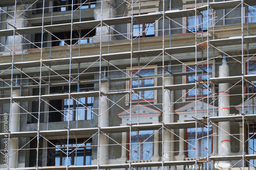 scaffolding at the facade of a building under construction, multi-storey building, without people