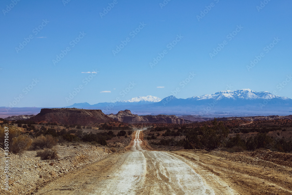 Empty back dirt roads in Utah with mountains in distance Empty back dirt roads in Utah with mountains in distance