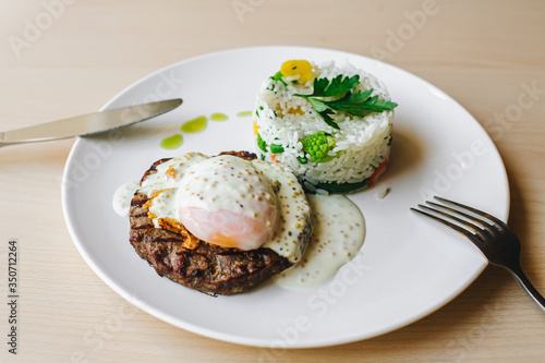 poached egg on steak with rice garnish