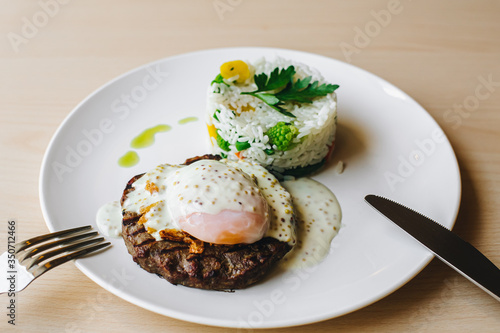 poached egg on steak with rice garnish