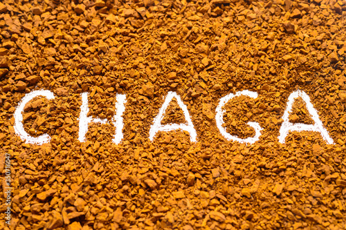 chaga mushroom. handwritten text chaga in a background of a pile of small fragments of birch fungus chaga photo