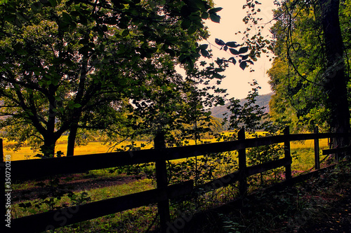 Sunrise on a farm field behid a wooden fence