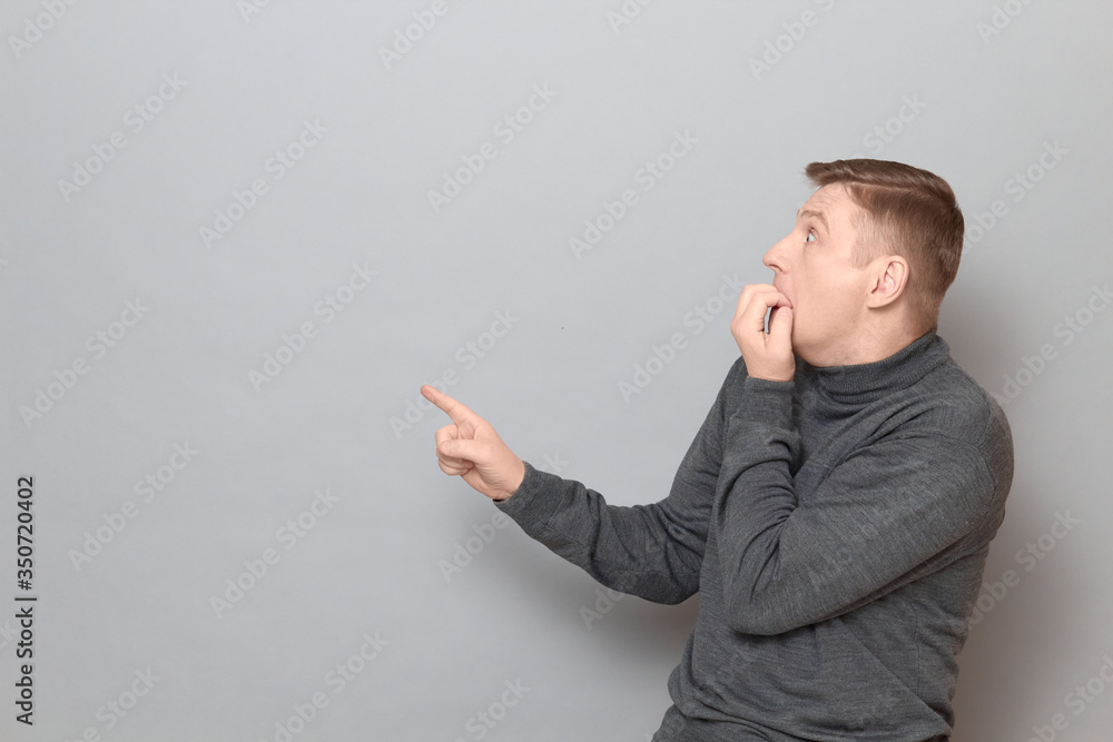 Shot of shocked frightened man pointing with finger at something awful Shot of shocked frightened man pointing with finger at something awful