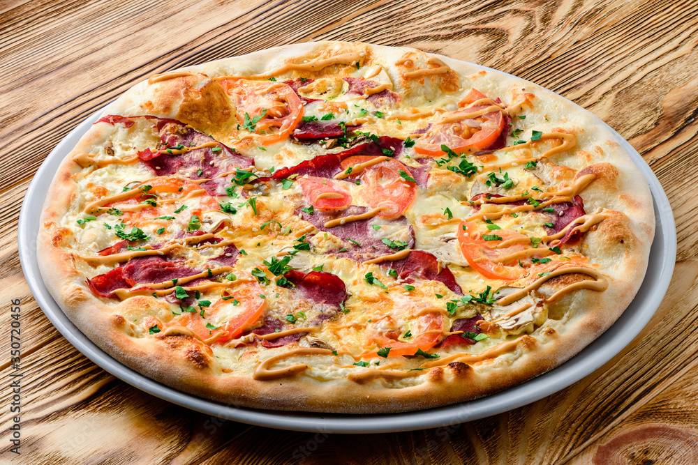 Italian pizza on a thin dough with a variety of stuffed. Mixed media Italian pizza on a thin dough with a variety of stuffed. Mixed media
