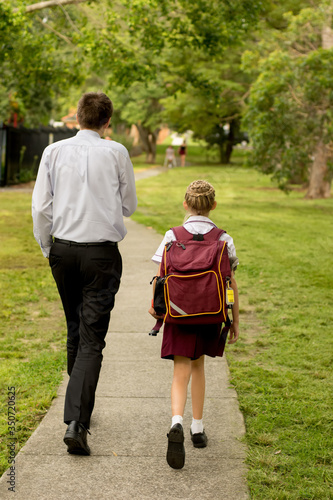 Father and daughter walking to school. NSW public school students to return to classrooms full time after coronavirus shutdown on 25th May 2020 © Daria Nipot
