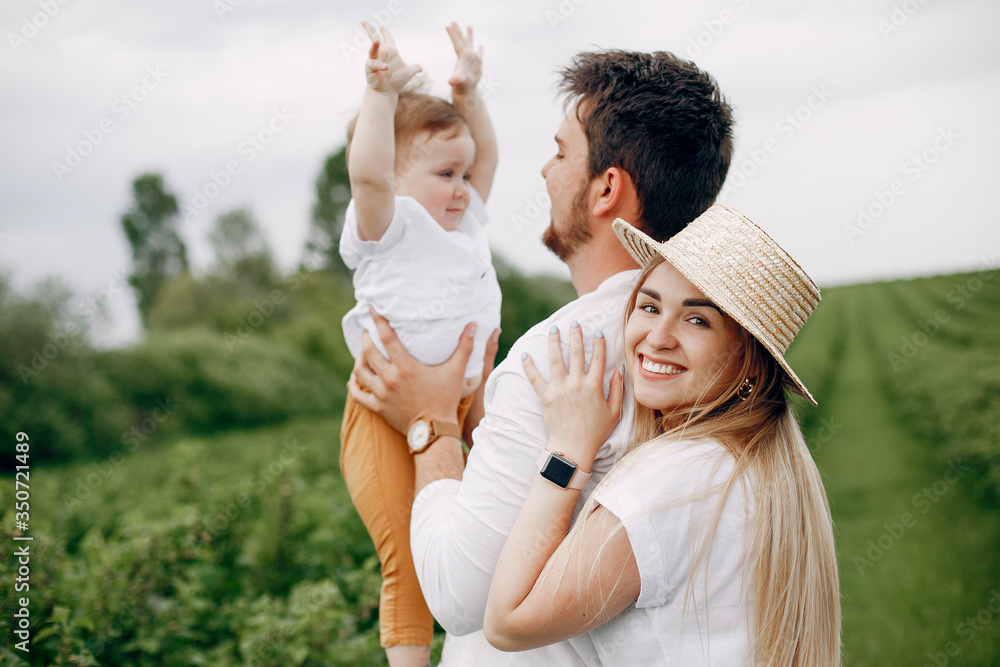 Family with cute little son. Father in a white t-shirt. Lady in a white dress