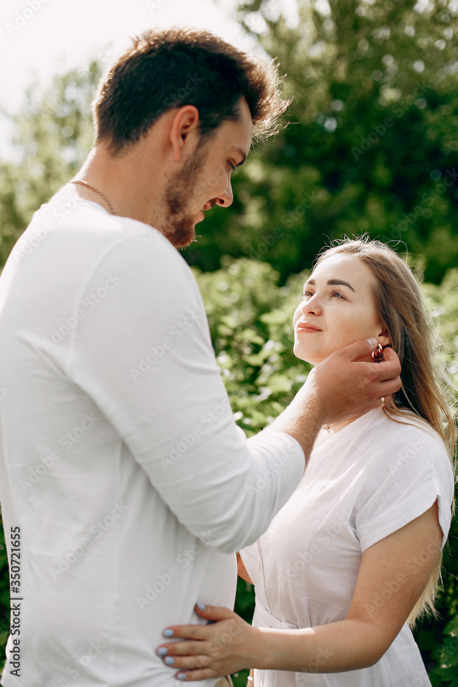 Couple in a field. Blonde in a white dress. Man in a white shirt Couple in a field. Blonde in a white dress. Man in a white shirt