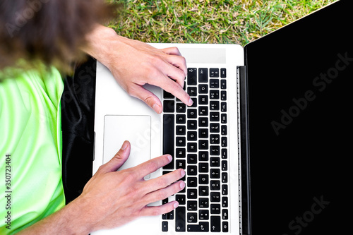 Wallpaper Mural Young student using a modern laptop in the garden of his house. Torontodigital.ca
