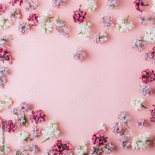 Floral pattern made of lilac flowers on pink background. Flat lay. Floral purple frame