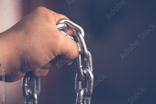 Metal chain in male hand with blurry background