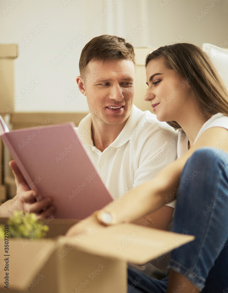 Cute couple unpacking cardboard boxes in their new home Cute couple unpacking cardboard boxes in their new home