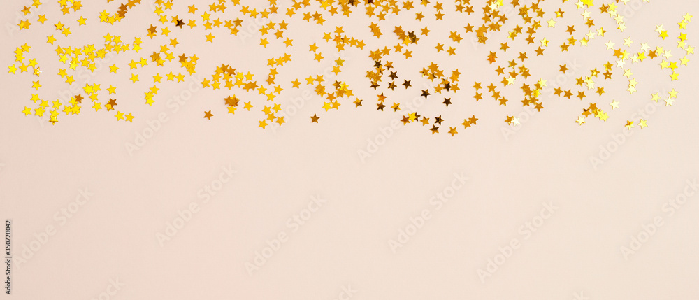 Golden stars in the form of confetti on beige background. Top frame border Golden stars in the form of confetti on beige background. Top frame border